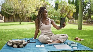 Afrika kökenli Amerikalı bir kız öğrenci kampüs üniversitesinde gülümseyen dokunmatik yastıkla selfie çekiyor.