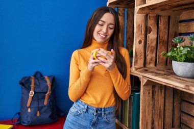 Genç ve güzel İspanyol kadın evde kahve içiyor.