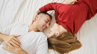 Bir erkek ve bir kadın samimi bir bakışla birbirlerine bağlanırlar, sıcak bir yatak odası ortamında bir yatakta birlikte uzanırlar..