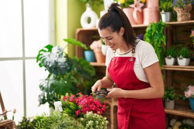 Çiçekçide çiçek kesen güzel İspanyol kadın.