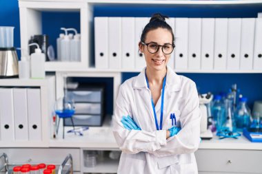 Young caucasian woman scientist smiling confident standing with arms crossed gesture at laboratory