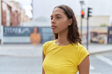 Young african american woman looking to the side with serious expression at street