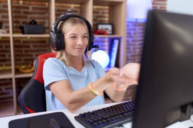 Video oyunları oynayan, kulaklık takan, avuçlarıyla gülümseyen, el hareketi yapan beyaz bir kadın. Bekleme ve koruma 