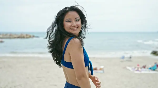 Young chinese woman tourist smiling confident wearing bikini at the beach