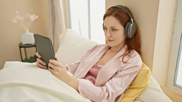 Uma Mulher Ruiva Serena Usando Fones Ouvido Desfruta Seu Tablet — Fotografia de Stock