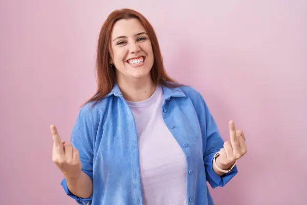 Young Hispanic Woman Red Hair Standing Pink Background Showing Middle — стоковое фото