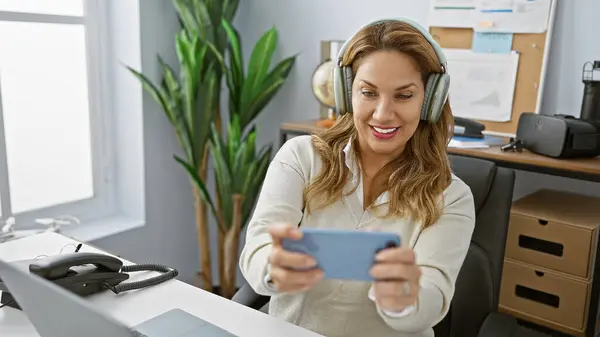 Modern Ofis Ortamında Akıllı Telefon Kullanan Kulaklık Takan Gülümseyen Bir — Stok fotoğraf