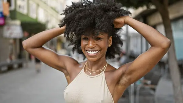 stock image African american woman smiling confident touching hair at coffee shop terrace