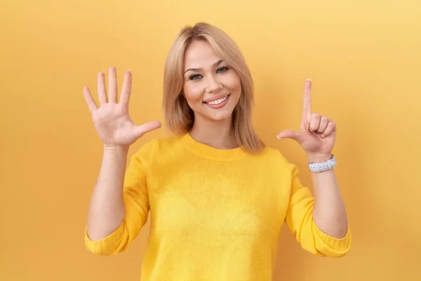 Joven Mujer Caucásica Con Suéter Amarillo Mostrando Señalando Hacia Arriba —  Fotos de Stock