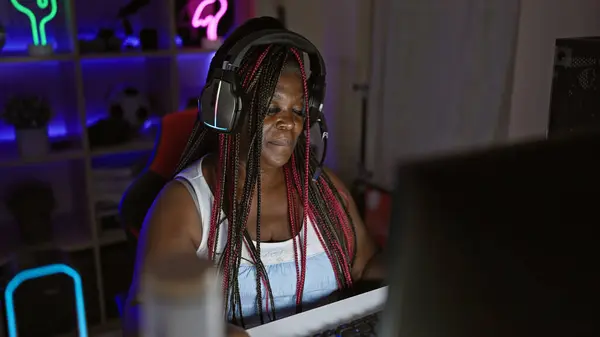 Passionate african american woman streamer bringing virtual magic into the night, streaming live game from her tech-rich gaming room