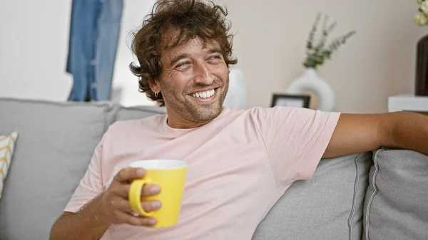 Lächelnder Hispanischer Mann Entspannt Sich Mit Kaffee Auf Sofa Gemütlichen — Stockfoto