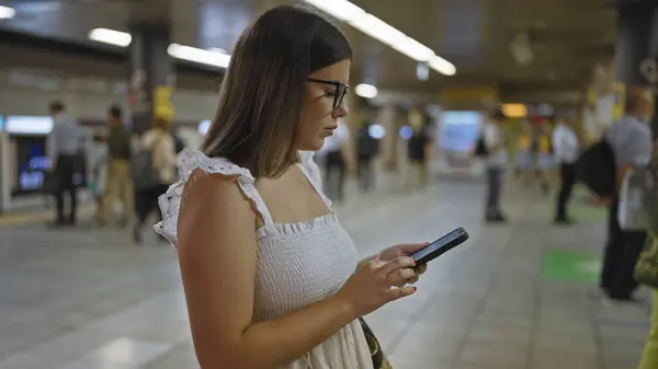 素晴らしいヒスパニックの女性 メガネ 地下鉄駅に立って 彼女の地下鉄の旅を予想し 彼女の携帯電話に囲まれた — ストック写真