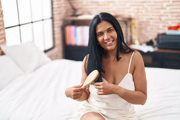 Middle Age Hispanic Woman Combing Hair Sitting Bed Bedroom — Stock Photo, Image