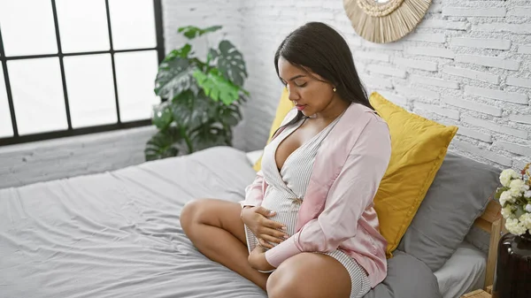 Pensativa Joven Embarazada Tocándose Vientre Sentada Cama Tranquila Mañana Abrazando —  Fotos de Stock