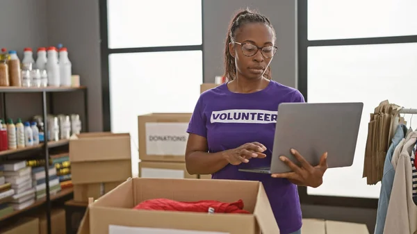 Africano Americano Mulher Voluntariado Centro Doação Usando Laptop Cercado Por — Fotografia de Stock