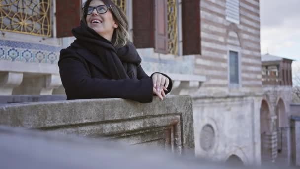 Mujer Sonriente Con Gafas Abrigo Negro Apoya Balcón Histórico Estambul — Vídeo de stock