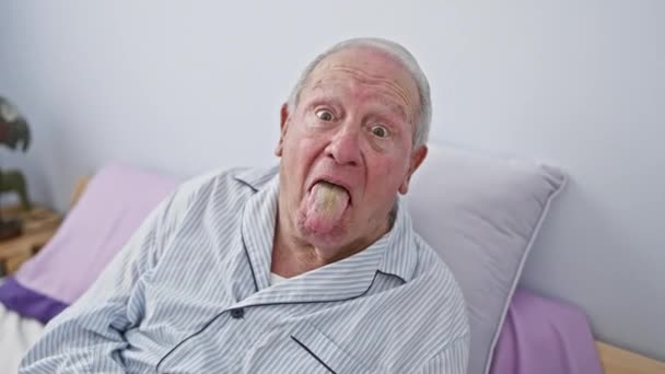 Χαρούμενος Ηλικιωμένος Άνδρας Πιτζάμες Κάθεται Στο Κρεβάτι Στην Κρεβατοκάμαρα Βγάζοντας — Αρχείο Βίντεο