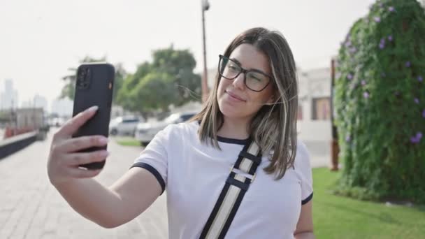 年轻女子在阳光明媚的道哈街上拿着智能手机自私自利 体现了旅游和城市生活方式 — 图库视频影像