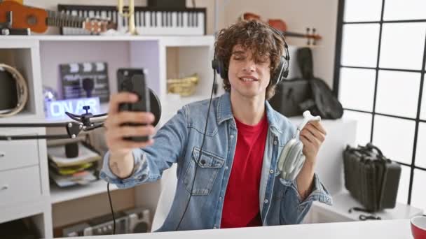 Jovem Adulto Com Fones Ouvido Tira Uma Selfie Estúdio Música — Vídeo de Stock