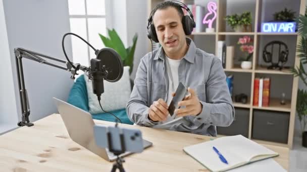 Χαμογελώντας Άνθρωπος Ακουστικά Ένα Στούντιο Podcast Αλληλεπιδρά Smartphone Και Συσκευή — Αρχείο Βίντεο