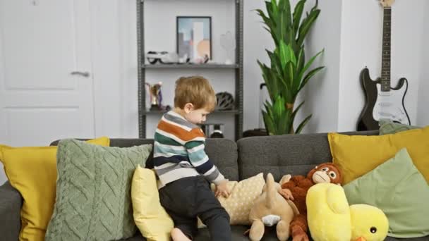Adorável Criança Menino Sentado Sofá Com Brinquedos Ambiente Acolhedor Sala — Vídeo de Stock