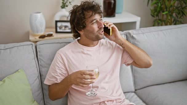 Oturma Odasında Şarap Kadehi Tutarken Telefonda Konuşan Gevşemiş Spanyol Adam — Stok video