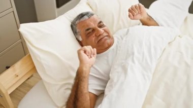 Gülümseyen son sınıf öğrencisi rahat bir yatak odasında rahatlıyor, mutluluk ve rahatlık hissi veriyor..