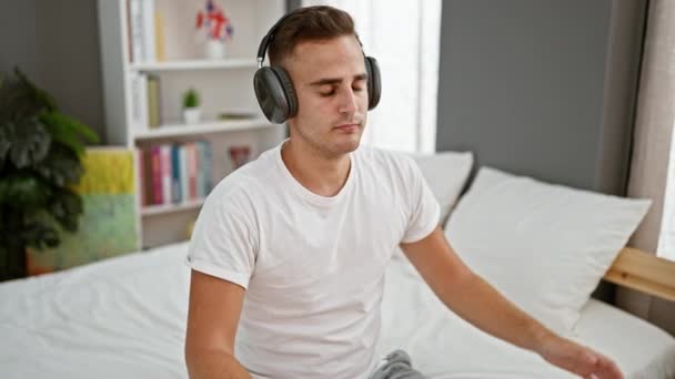 Zrelaksowany Mężczyzna Słuchawkami Słucha Muzyki Nowoczesnej Sypialni — Wideo stockowe
