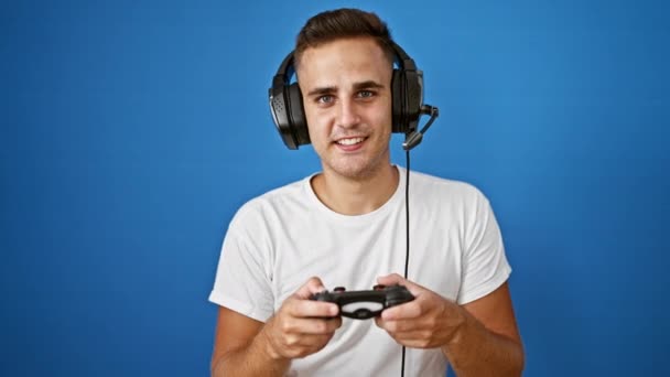 남자는 파란색 배경에 헤드폰을 비디오 게임을 — 비디오