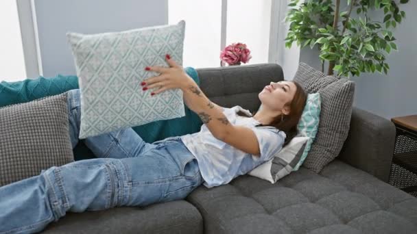 Una Mujer Relajada Descansando Sofá Gris Tirando Una Almohada Turquesa — Vídeos de Stock