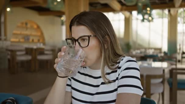 Gözlük Takan Bir Kadın Geçmişi Bulanık Modern Bir Restoranda Içiyor — Stok video
