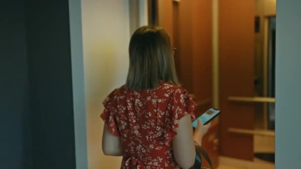 モダンなホテルのエレベーターに乗り ホールにエレガントに立って 仕事中の若い大人の女性の美しい肖像 — ストック動画