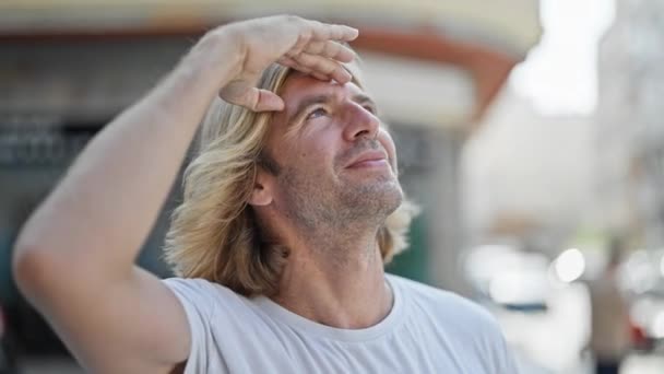 Blond Man Outdoors Shading Eyes Sun Urban Street — Stock Video