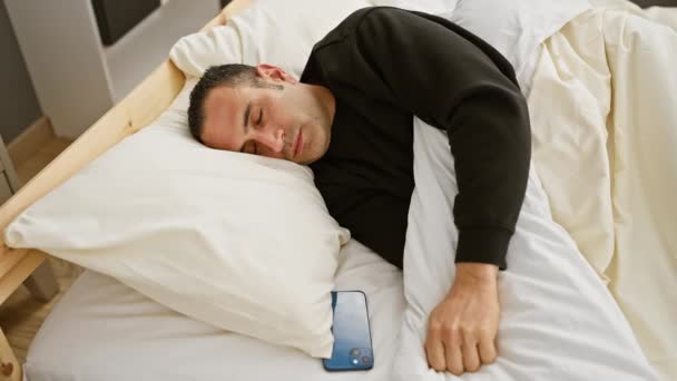 Joven Hombre Hispano Despertando Dormitorio Revisando Teléfono Inteligente Mientras Está — Vídeos de Stock