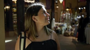 Gülümseyen genç bayan turist Dubai 'de geleneksel pazar yerinde eğleniyor..