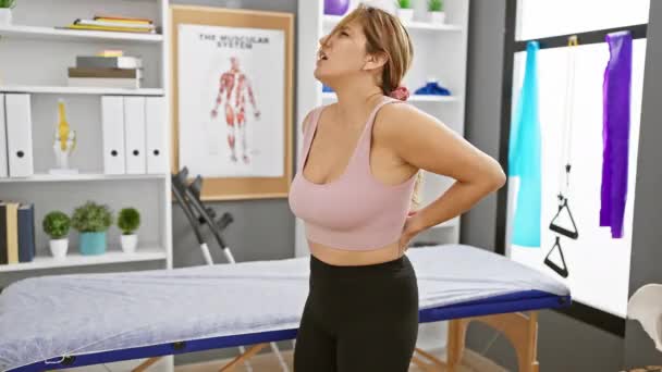 Eine Hispanische Frau Erlebt Rückenschmerzen Einer Physiotherapeutischen Klinik Und Zeigt — Stockvideo