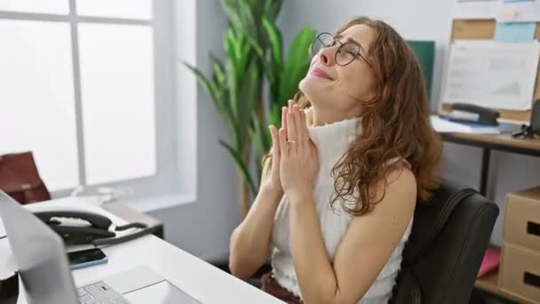 绝望的年轻女性在工作中祈祷 在情绪化的恳求中满怀希望的表情 手拉手在办公室里 — 图库视频影像
