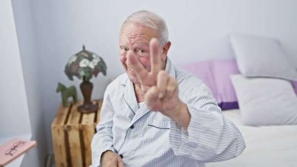 Winning Senior Man Pyjama Showing Victory Sign Two Fingers Sitting — Stock Video