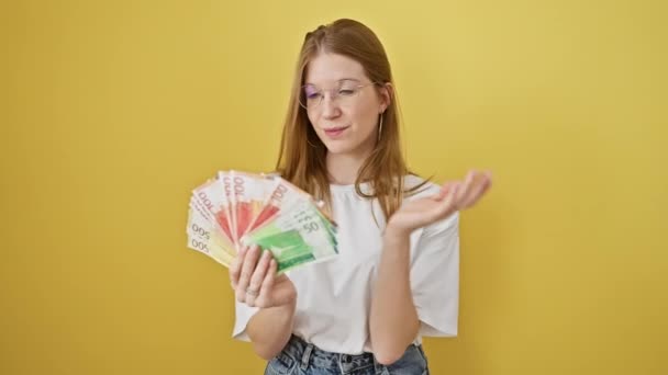 Mujer Rubia Caucásica Sostiene Moneda Noruega Contemplando Sobre Fondo Amarillo — Vídeo de stock
