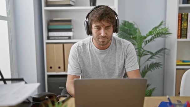 Homem Focado Com Fones Ouvido Trabalhando Laptop Ambiente Escritório Moderno — Vídeo de Stock