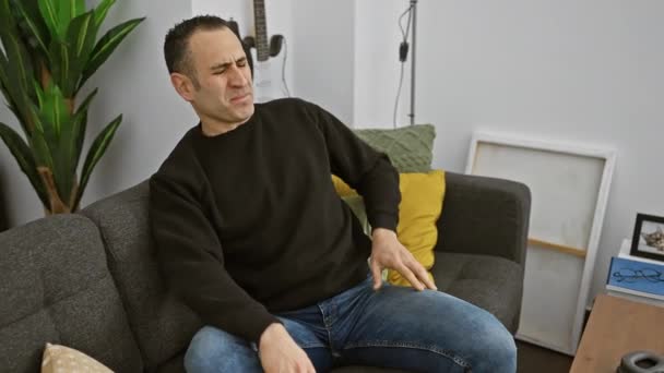 Bolestivý Muž Sedí Nepohodlně Šedé Pohovce Moderním Obývacím Pokoji Chytá — Stock video