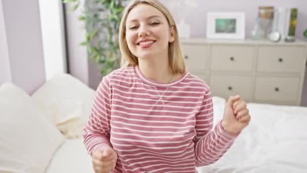 Uśmiechnięta Przypadkowa Młoda Blondynka Gestykulująca Relaksująca Się Swojej Sypialni Domu — Wideo stockowe