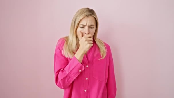 美丽的金发女子站在不舒服的地方 在一个孤立的粉色背景上咳嗽着 在医疗保健压力下可能出现的感冒或支气管炎恐慌 — 图库视频影像