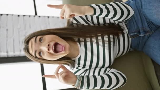 Молодая Латиноамериканка Сидя Диване Изумлялась Удивлялась Глядя Вверх Показывая Пальцами — стоковое видео