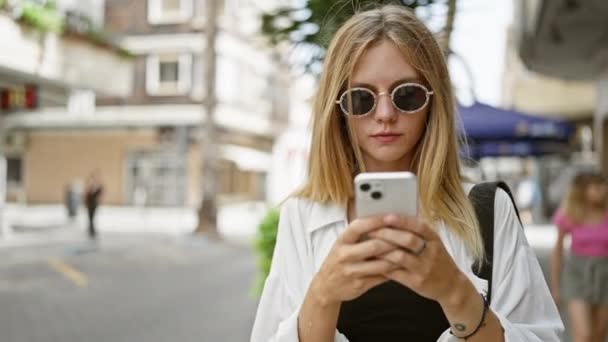 Ung Attraktiv Kvinna Med Blont Hår Och Solglasögon Använder Smartphone — Stockvideo