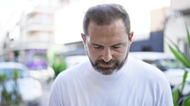 Şehirdeki bulanık bir sokakta gülümseyen yakışıklı, orta yaşlı İspanyol bir adam..