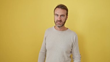Hayal kırıklığına uğramış orta yaşlı İspanyol adam, yumruklarını sıktı, öfkeden köpürdü. Deli, saldırgan sarı duvara karşı duruyor. Yüzünde ciddi ve üzgün bir ifade var.