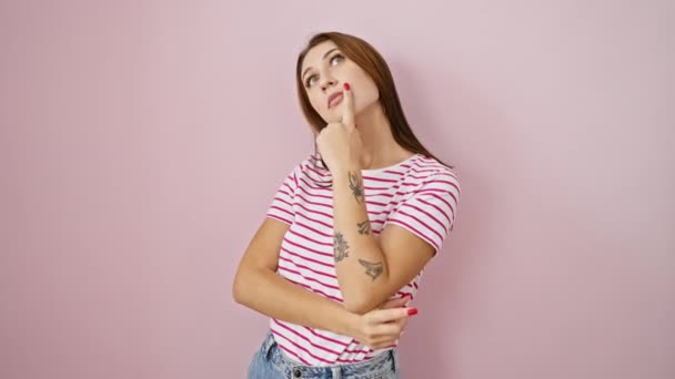 ストライプシャツの思慮深い若いブルネットガール 中国の手 パズル問題を引き裂く 彼女のかわいい顔に明白な疑問 孤立したピンクの背景に対してポーズ — ストック動画