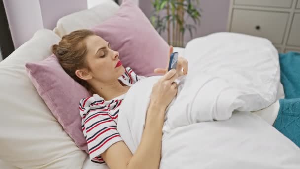 Латиноамериканка Расслабляется Телефоном Спальне Изображая Связанный Образ Жизни Дома — стоковое видео