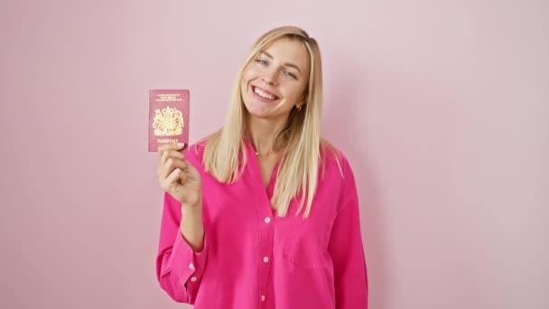 快乐的金发女子 来自北部岛屿的护照 背景是粉色的 带着淡淡的微笑散发着自信 — 图库视频影像